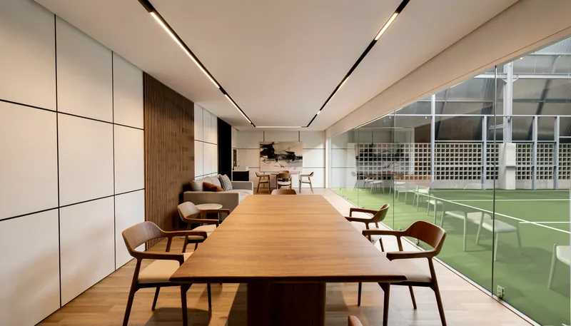 Private room with a long table along the glass wall to the courts