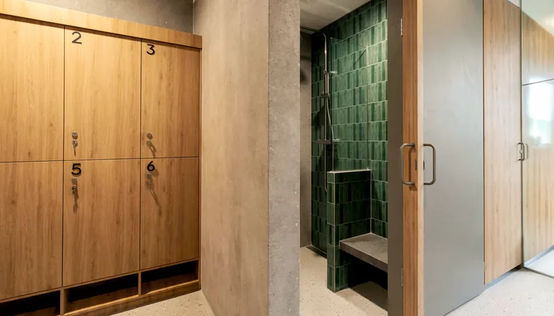 Timber lockers beside a green-tiled shower